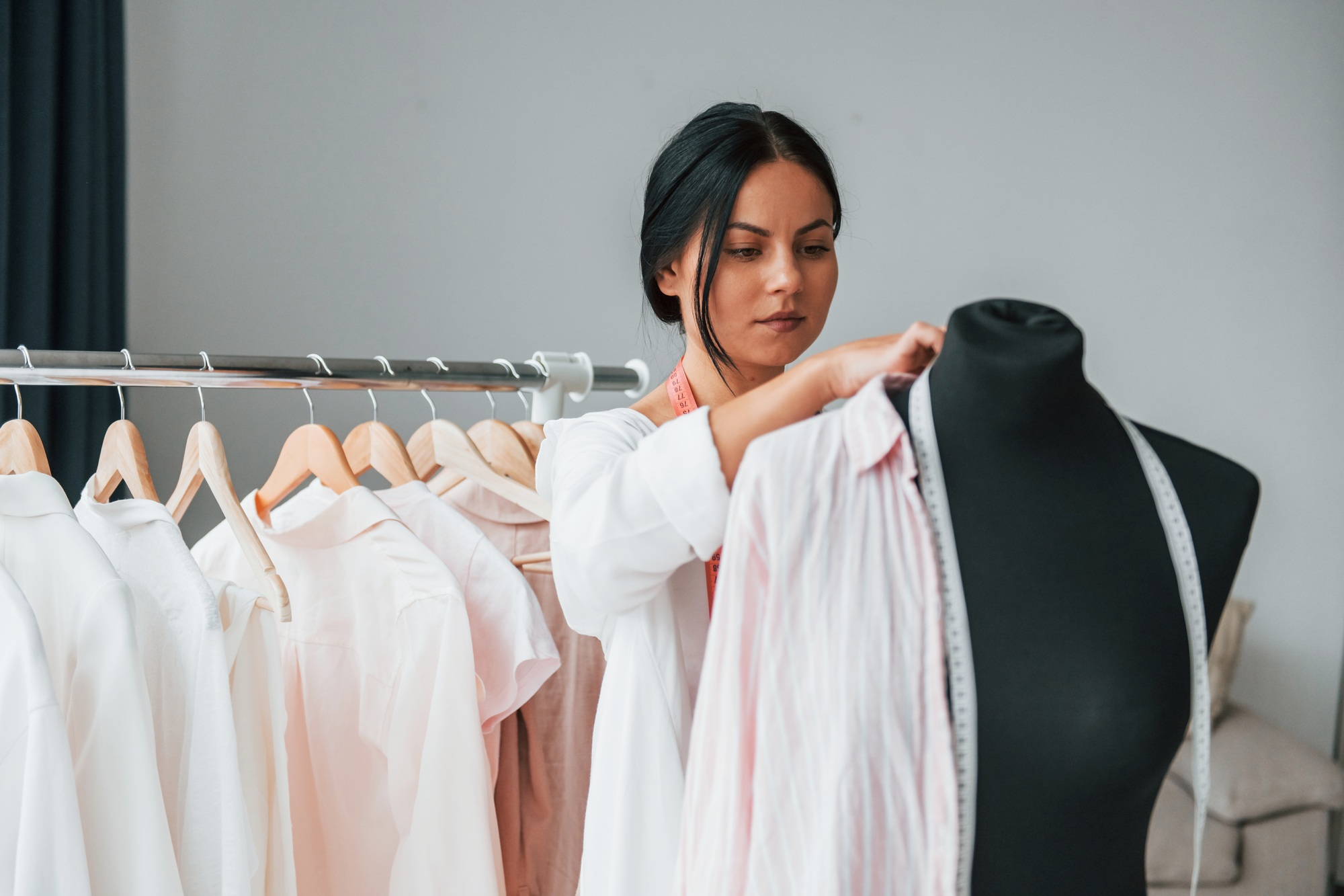 Conception of fashion. Seamstress is in her office that is with different clothes
